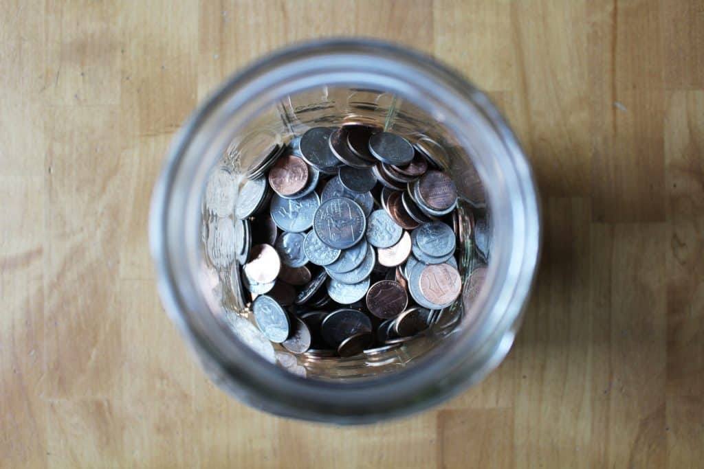 clear glass jar with coins inside