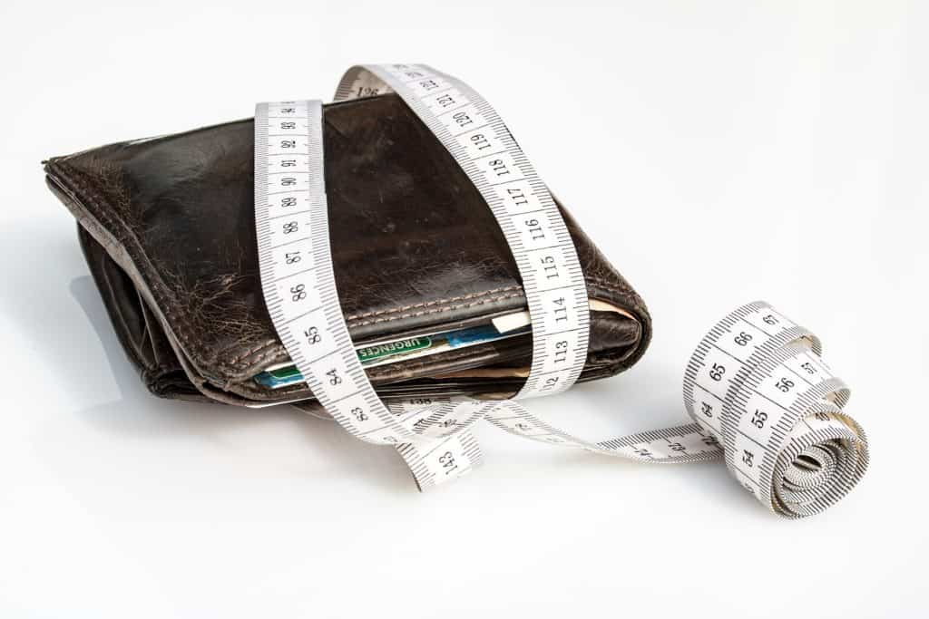 brown wallet with white measuring tape wrapped around it